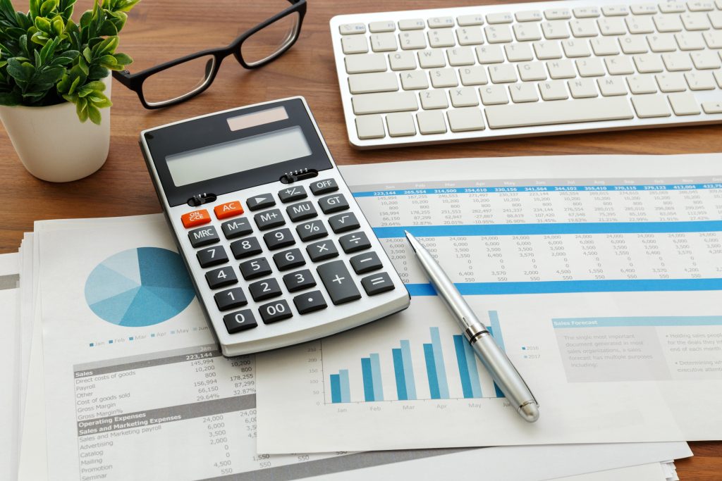 Financial accounting with calculator and financial chart data and computer keyboard.